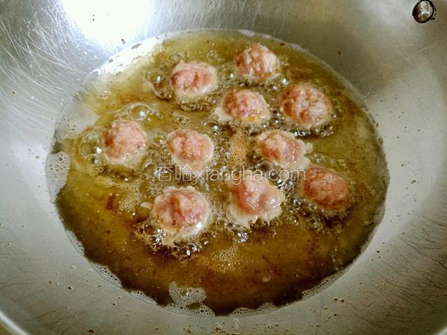 锅中多放点油烧热，将肉馅用勺子舀成小肉丸放进油锅里炸制(我分成两锅炸制)。