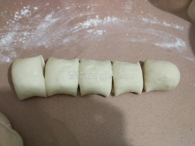 拿出来加点干面粉再揉一揉排气，刷成长条切成大小均匀的面团