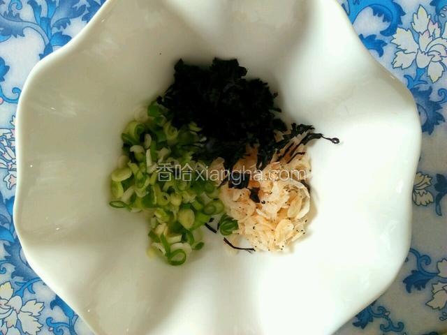 碗里放入切好的葱，一点虾皮，还有紫菜，紫菜要撕碎。