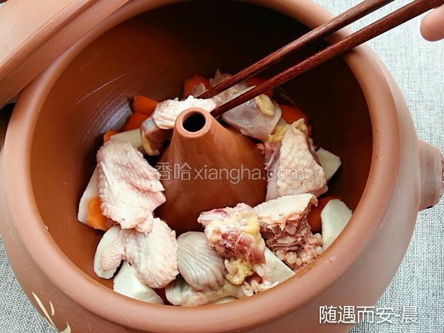 将山药和胡萝卜按自己喜好切块、铺在锅底，洗净的土鸡码在上面