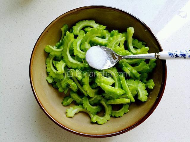 把苦瓜放在碗里，放入少许食盐，腌制十分钟左右。