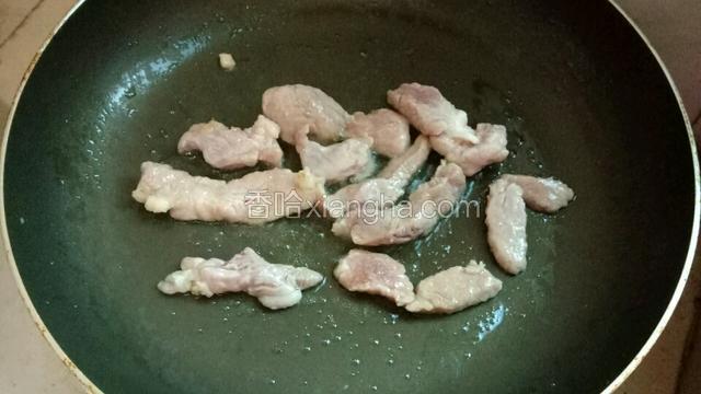 热锅倒入油，放进里脊肉煎至变色。