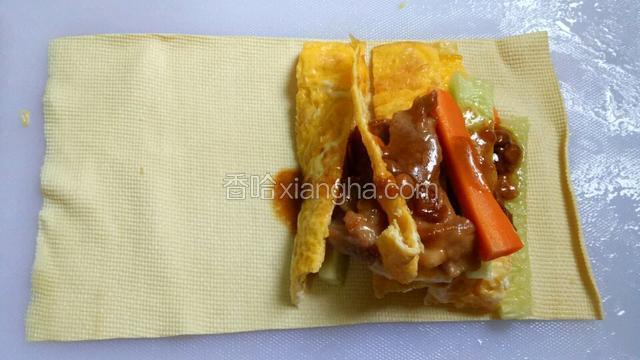 豆皮摊好，将胡萝卜条，青瓜条，鸡蛋，肉摆放在豆皮的一端，淋上酱汁。