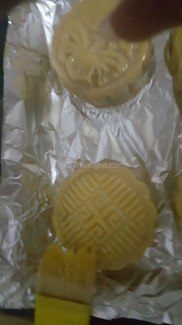 5分钟后拿出烤盘用柔软的毛刷在月饼表面刷一层薄薄的蛋液。