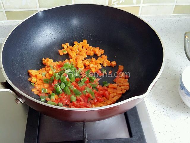 将胡萝卜丁、青红椒丁煸炒至6分熟。