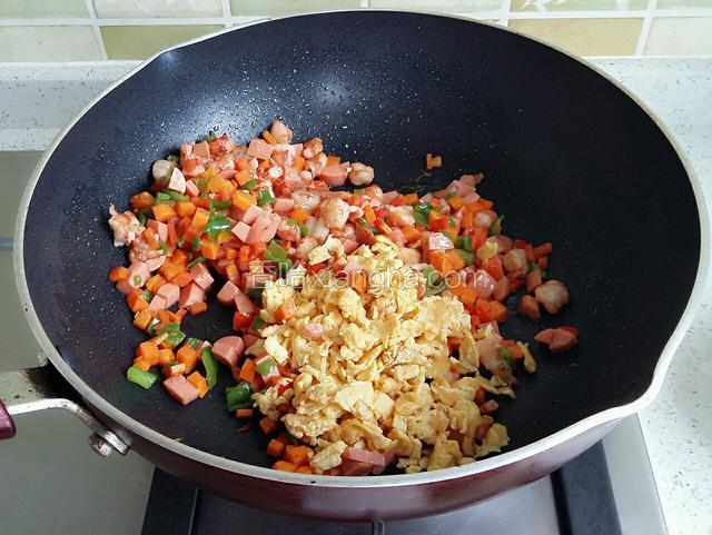 加入火腿、蛋碎、虾丁炒匀。