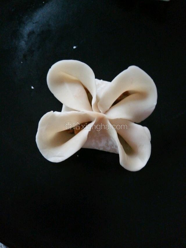 两边对折捏紧中间，那两边也折过来，都在中间捏紧，再把四角打开一点。