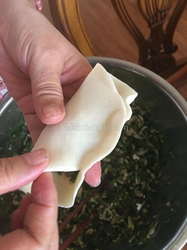 用右手把面皮折合捏住。