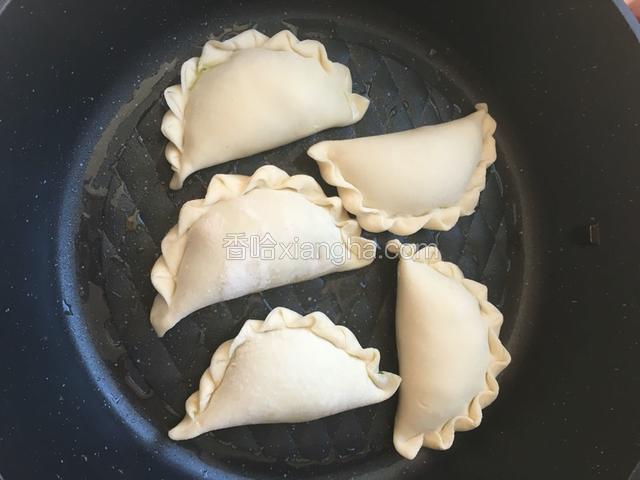 准备不沾平底锅烧热，放入少许色拉油，放入韭菜盒子开始煎。