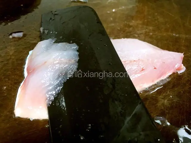 生鱼肉用刀从右向左片出薄薄的鱼片。
