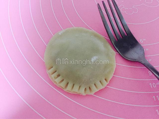 用手将两个面皮捏合在一起，再用叉子压出花边