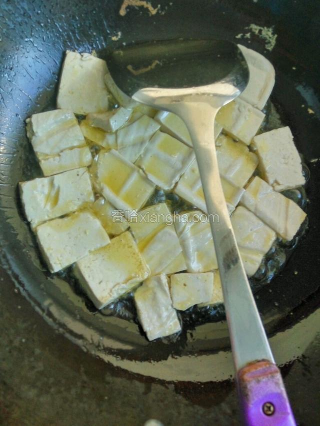 豆腐沥去水，用厨房纸吸干水。热锅冷油，放入豆腐块煎