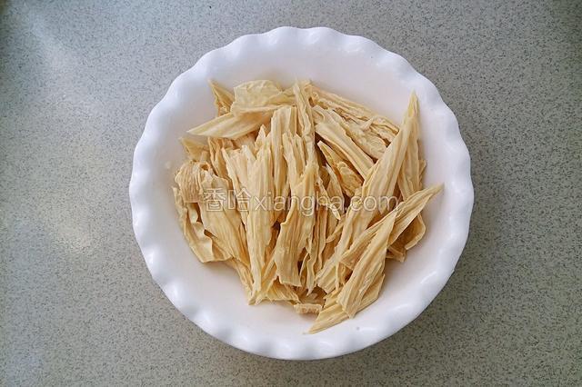 腐竹用清水侵泡三四个小时，泡软后斜切成小段。