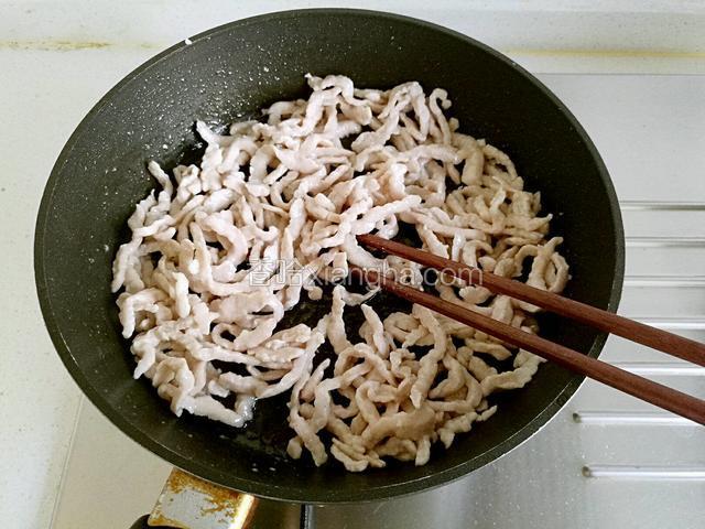 把肉丝放入，快速用筷子划散，然后炒至变色后盛出备用。