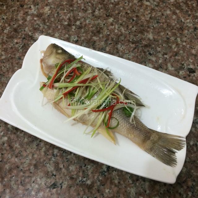 蒸熟的鱼取出，汤汁倒掉，姜和葱丝去掉。撒上姜丝和葱丝，红椒丝。