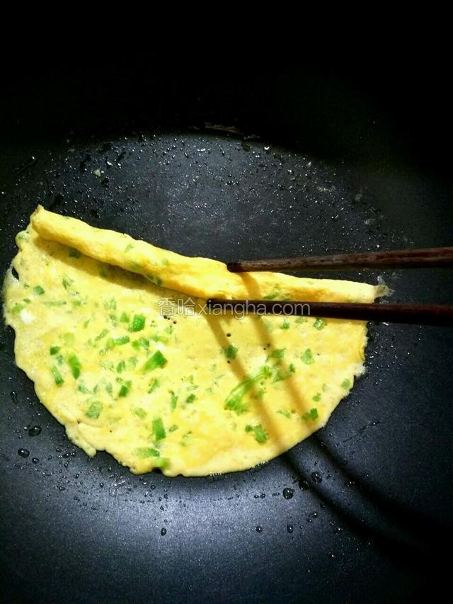 待蛋液凝固后用筷子卷起来