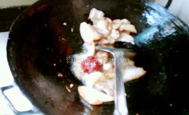 加入豆瓣酱炒出红油，再加入料酒炒匀加入酱油和白糖炒香上色。