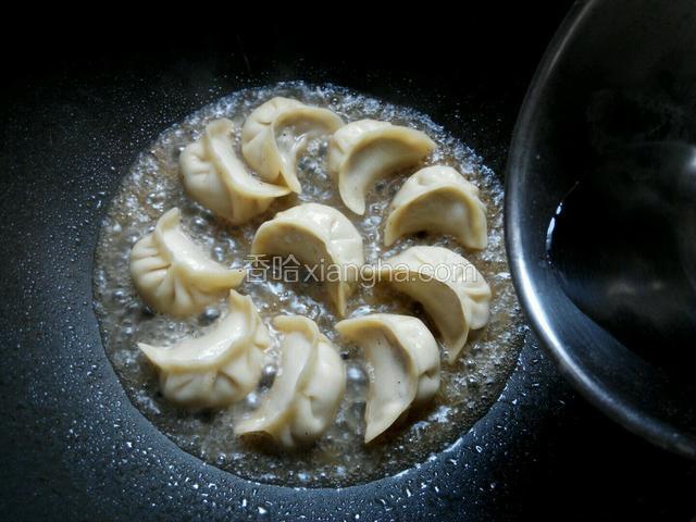 饺子稍微煎一下，放入饺子一半高的水，盖上锅盖，煮熟。