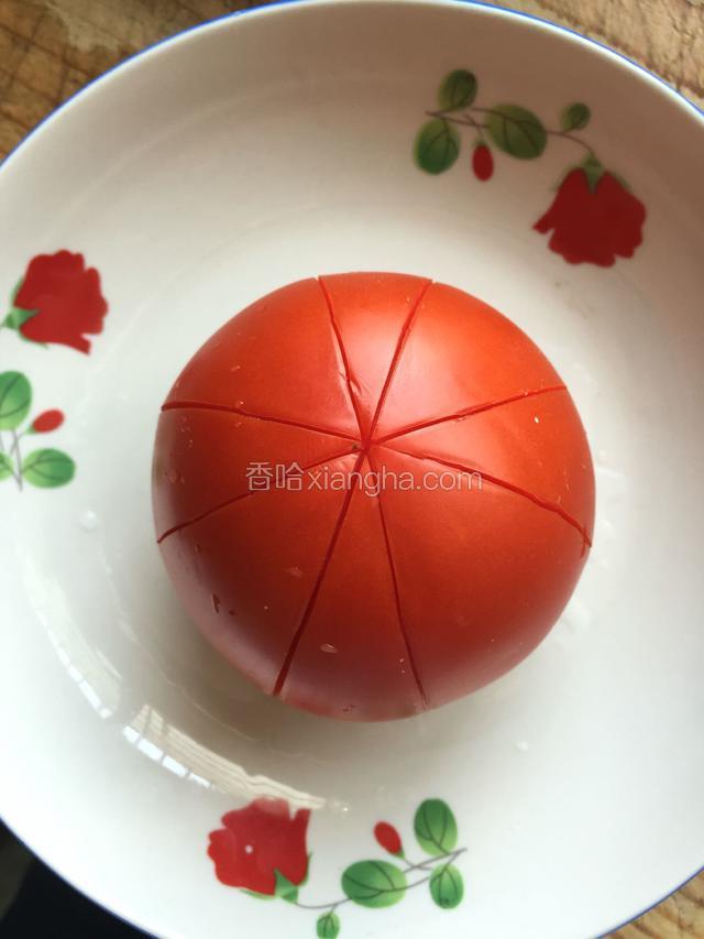 取出西红柿放入盘，用刀子切米字，不要切进去太深，要不然不好撕破皮