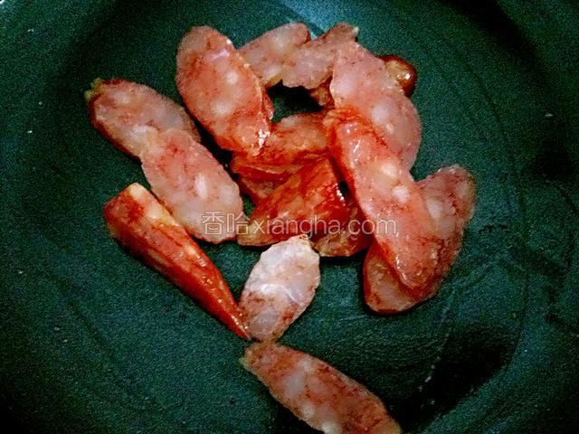 起锅烧干水，倒入腊肠。无需加油。