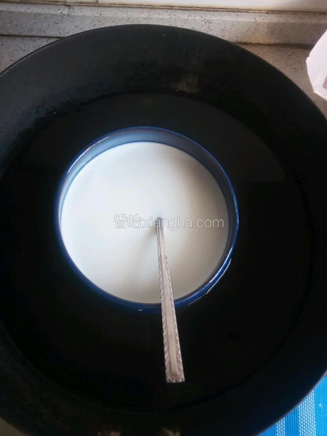 锅中放热水，将碗放入，水浴加热，不时搅拌，直至炼乳完全溶解，牛奶温热