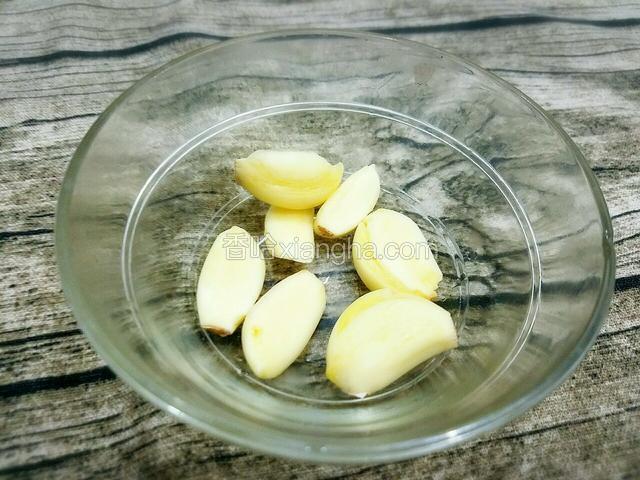 将大蒜去皮拍扁。