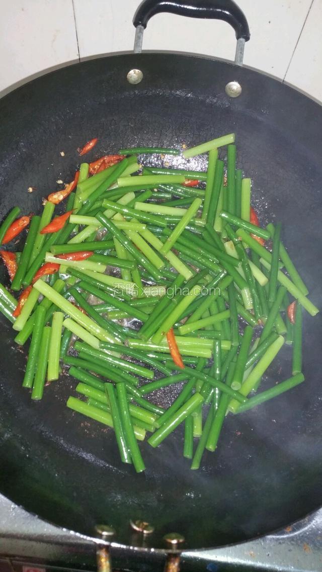 倒入蒜台，翻炒一分钟，倒入炒好的瘦肉，调入适量的盐，跟酱油，翻炒均匀