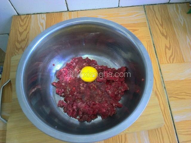 牛肉馅放入盆子，放入两勺生抽，一个鸡蛋顺时针搅拌均匀。