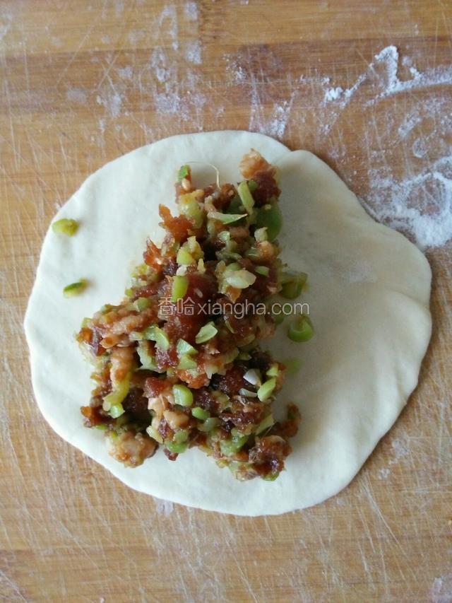 包入馅料，左手端包子，右手拇指和食指依次提起褶子捏好收口。