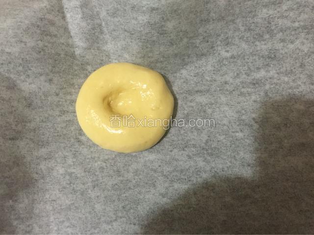 烤盘铺上油纸，把面团放入后用手指在面团中间压个洞