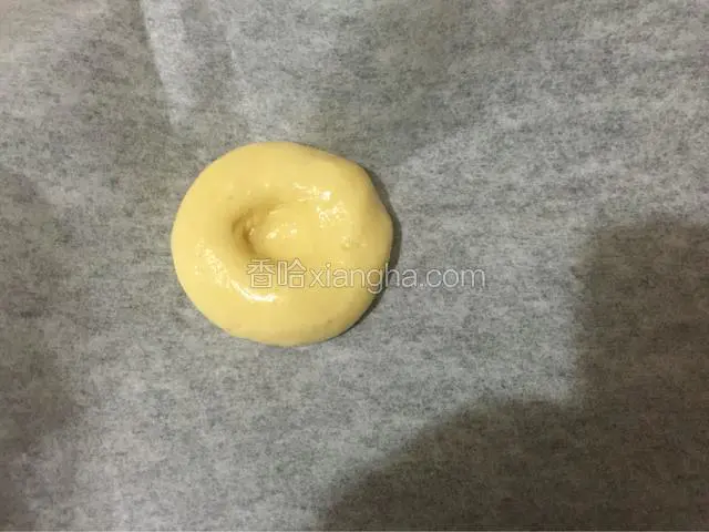 烤盘铺上油纸，把面团放入后用手指在面团中间压个洞