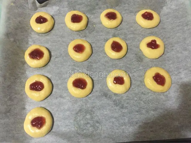 用小勺把草莓酱放在面团的小洞中