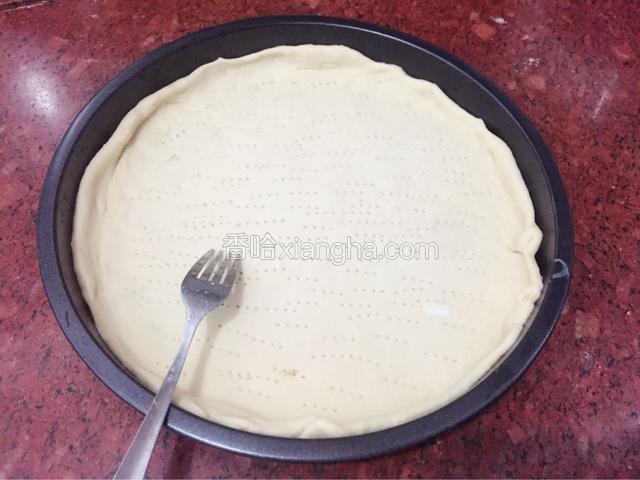 先取适量的面团擀成圆形面片（薄厚可以自己决定），模具提前抹上一层薄油再放入擀好的面片（饼胚的周围要压出一道边），最后用叉子扎满小孔