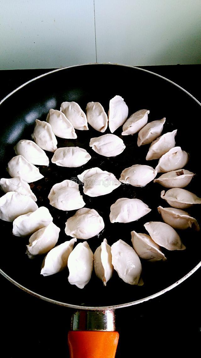 锅置火上，倒入适量油，将饺子一个一个码在锅里，小火煎至底部金黄。
