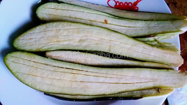 茄子一刀破两边，再划几刀，摸上盐腌制十分钟。