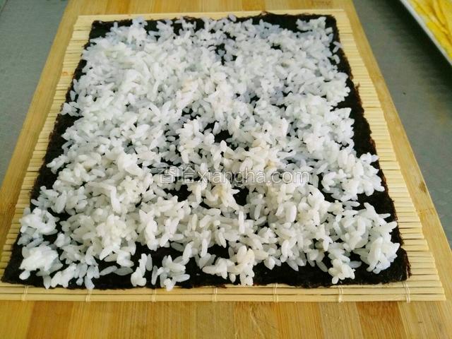 再把拌好寿司醋的米饭平铺上面。