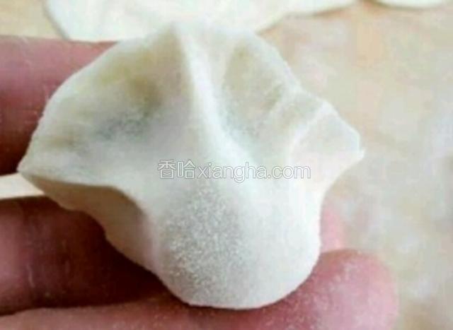 将饺子放在两手食指上，一起用力往里窝，饺子捏好了