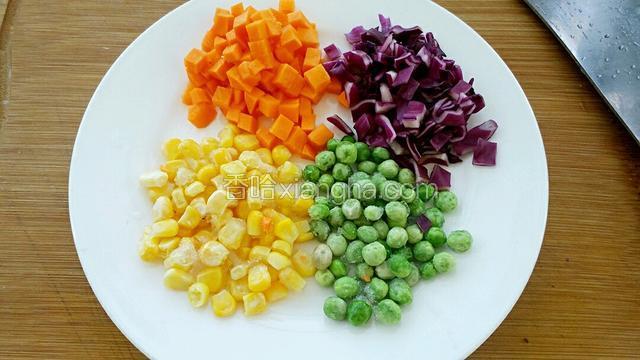 准备所需食材，把胡萝卜去皮切丁，紫甘蓝洗净切丁。