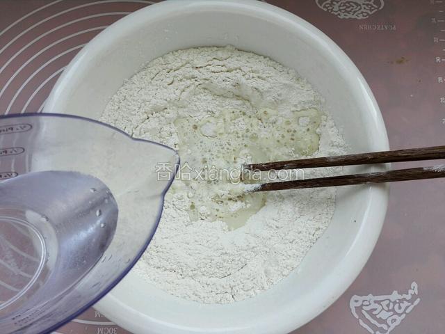 然后分次倒入温水和成面团。