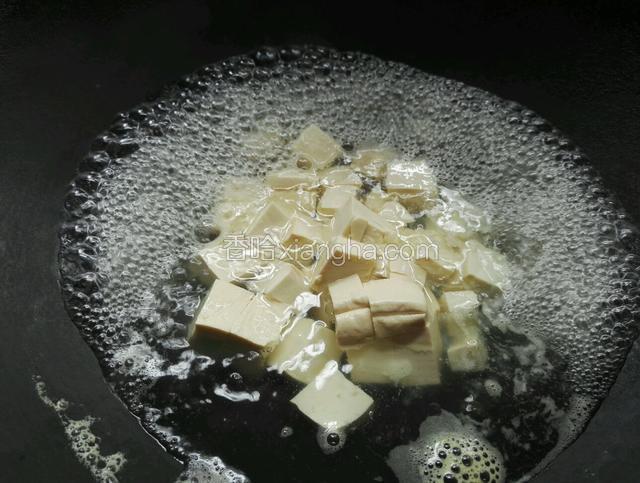锅里水烧开放入豆腐煮3分钟捞起备用沥干