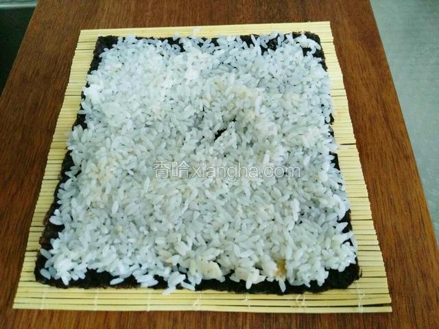 再把用寿司醋拌好的米饭平铺海苔上面。