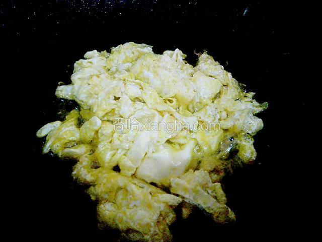 给锅里加入油，开大火，油温升高后，把蛋液倒入锅里，用木铲搅拌，然后把炒好的鸡蛋放入碗里备用，锅里的底油留着。