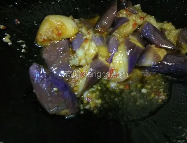 下蒸熟的茄子入锅翻炒均匀，给盐，鸡精，翻炒一下出锅