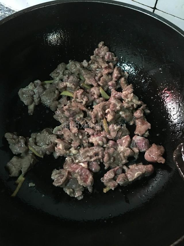 倒入腌渍好的牛肉翻炒至变色再下料酒