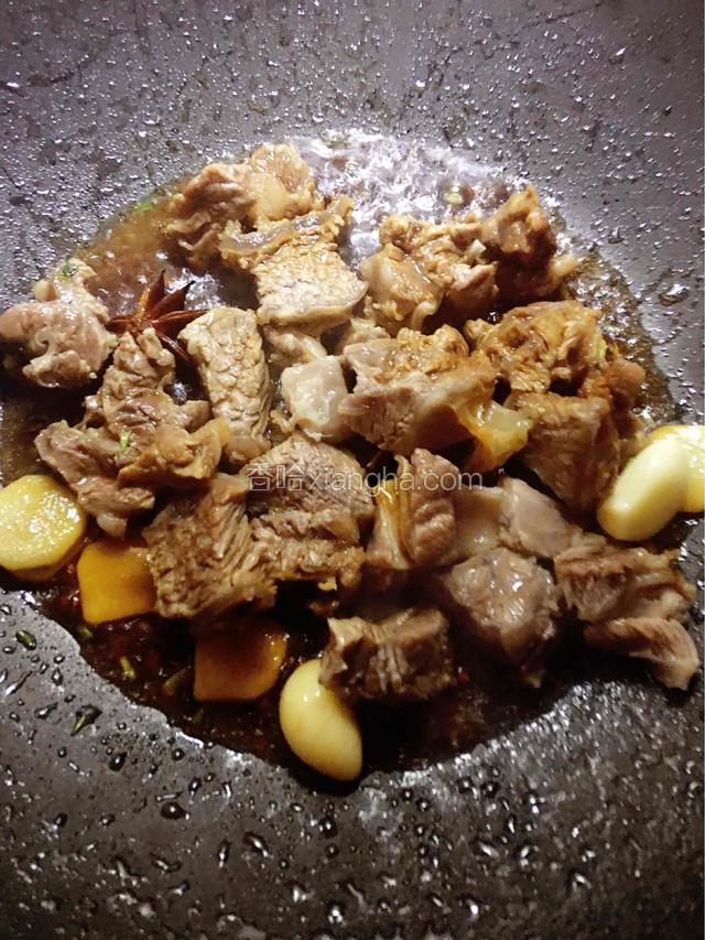 倒入牛腩，加入料酒生抽，翻炒至牛腩变色