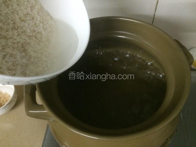 砂锅里倒入足够的清水，大火煮开后放入大米，倒入大米后，隔着一两分钟用勺子搅拌。