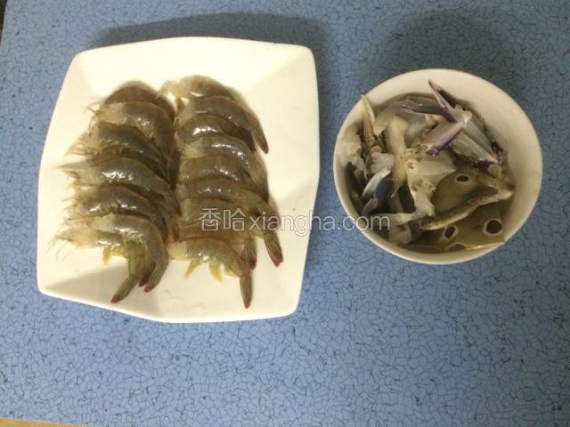 熬粥期间，把虾和和蟹处理一下，虾去掉虾头虾线，背部划开一刀，河蟹清洗干净，斩小块，用少许盐和料酒腌制一会儿，备用。