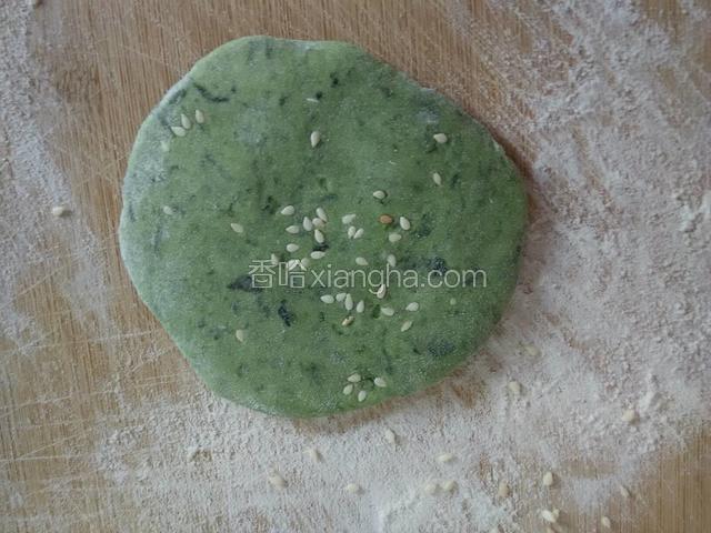把小剂子揉圆后压扁两面沾上白芝麻。