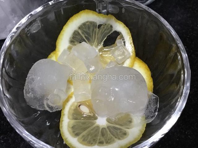 柠檬片加入杯中，挤入一些柠檬汁，加入冰块，冰糖