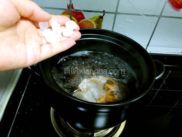 中火煮开后转小火，慢慢熬煮一个小时，将冰糖放入锅中。